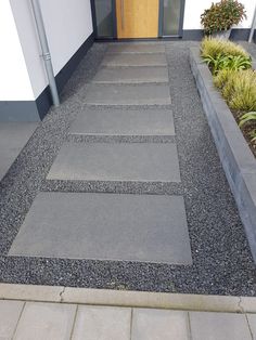 a walkway made out of concrete blocks next to a building