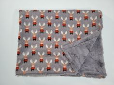 a gray blanket with red and white deer on it