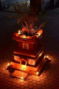 three tiered planter with candles lit up on the ground