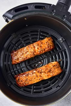 two salmons cooking in an air fryer