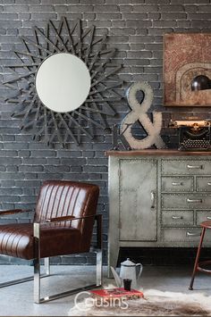 a room with a chair, mirror and other items on the table in front of a brick wall