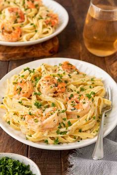 two plates of pasta with shrimp and parsley