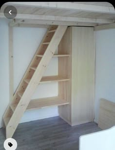 an empty room with a ladder to the ceiling and shelves on the wall next to it