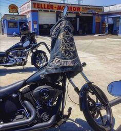 two motorcycles are parked in front of a building and one has a bandana on it