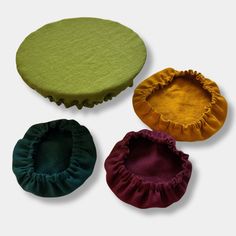 three different colors of round cushions with ruffles on the top and bottom side