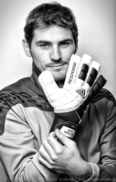 a black and white photo of a man holding a soccer goalie's glove