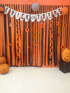 an orange and black halloween themed backdrop with pumpkins, jack - o'- lanternes and other decorations