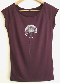 a purple shirt with a white dandelion on it