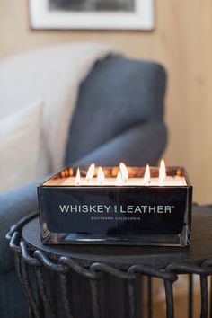 a lit candle sitting on top of a table in front of a blue couch and chair