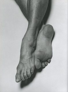 a black and white photo of a man's bare feet with no shoes on