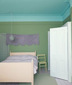 a bedroom with a bed, chair and green painted ceiling in the room is shown