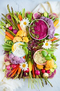 a platter filled with assorted vegetables and dips