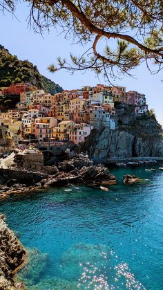 the water is blue and clear with houses on it's cliffs in the background