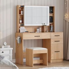 a wooden desk with a mirror, stool and lights on the wall in a room