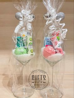 two clear wine glasses filled with different types of candy and candies in plastic bags