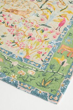 an area rug with various colors and designs on the floor, including flowers and animals