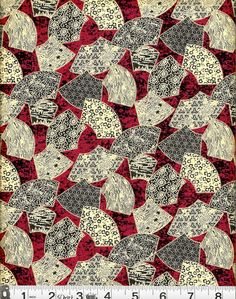 a red and white quilt with many different designs on the front, one in black