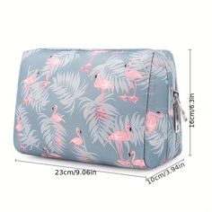 the pink flamingos and palm leaves are on this blue cosmetic bag with zippers