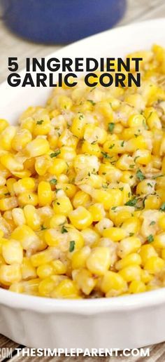 a white dish filled with corn and garnished with parsley on the side