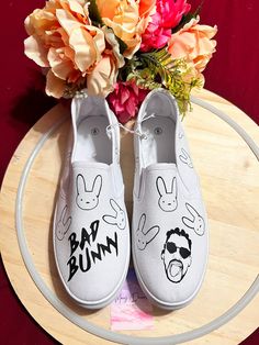 BAD BUNNY SLIP ON SHOES! Personalize this White slip on shoes with bad bunny design or any other design! If you have something on mind you show me the picture and I do it Also Available in youth and toddlers just ask! PLEASE READ IMPORTANT: -SHIPPING: *Shipping take about 1-4 business days! Shipping carriers will be USPS or UPS depends on how big its the package. After I leave a package in USPS or UPS its nothing I can do if they have a delay but I will be more than happy to help you if anything Bad Bunny Slippers, Bad Bunny Converse, Bad Bunny Shoes Adidas, Custom Vans Slip On Bad Bunny, Bad Bunny Personalized Shirt, Bunny Shoes, White Slip On Shoes, Personalized Shoes, White Slip