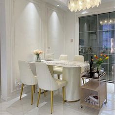 a dining room table with white chairs and a chandelier