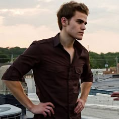 a man standing on top of a roof with his hands in his pockets