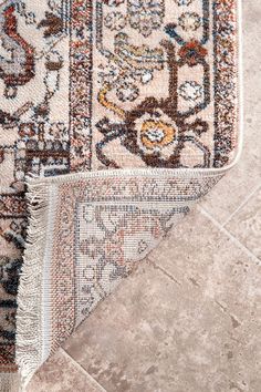 an area rug is laying on the floor next to a tile flooring swatch