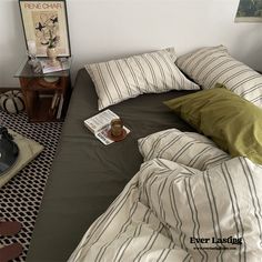 a bed that has some pillows on top of it and a lamp next to it