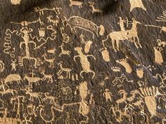 an ancient rock painting with animals and people on it