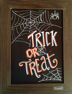 a chalkboard with the words trick or treat written in white and orange on it