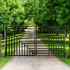 an open gate leading into a lush green park