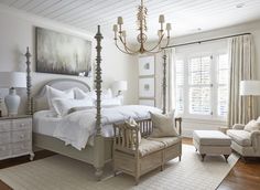 a bedroom with a bed, chair, and chandelier in it's center