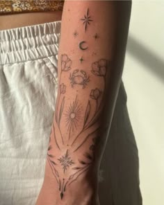 a woman's arm with flowers and stars on it