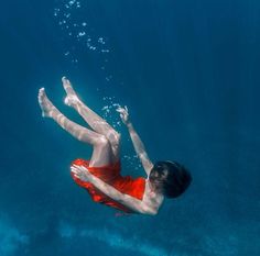 a man in red swimsuit swimming under water