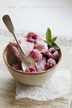 a bowl filled with ice cream and raspberries on top of a paper towel