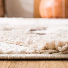 a white rug on top of a wooden floor