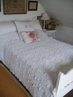 the bed is made with white linens and pillows