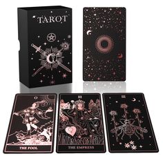 four tarot cards in front of a black box with pink and white designs on it