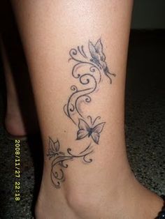 a woman's foot with a butterfly tattoo on the side of her leg,