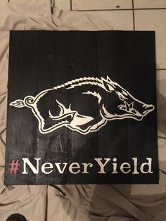 a wooden sign that says never yield with a boar's head painted on it