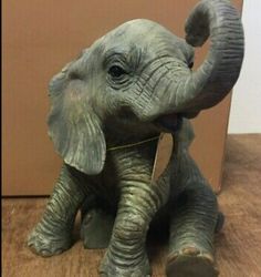 an elephant figurine sitting on top of a wooden floor next to a box