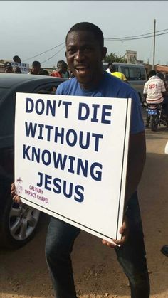 a man holding a sign that says don't die without known jesus