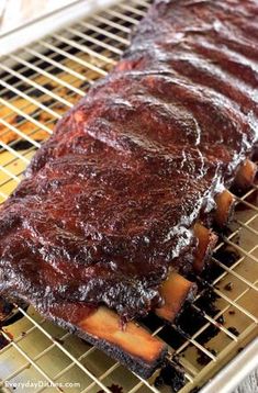 ribs on a grill with bbq sauce in the middle, ready to be cooked