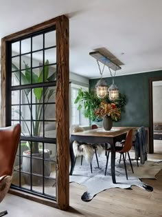 a dining room with a table and chairs in front of an open glass door that leads to the outside