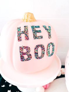 a pink cake with the words hey booo on it and sprinkles