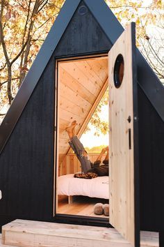 a small wooden cabin with a bed inside