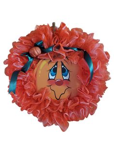 an orange frilly wreath with a face on it