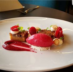 a white plate topped with dessert and fruit