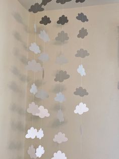 a mobile with clouds hanging from it's sides in a room next to a wall