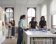 three women standing at a counter in a clothing store